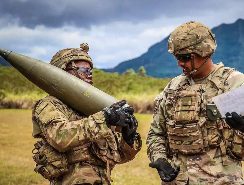 Soldiers handling an artillery round in the field