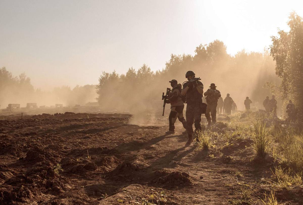 Infantry moving across open ground at dusk